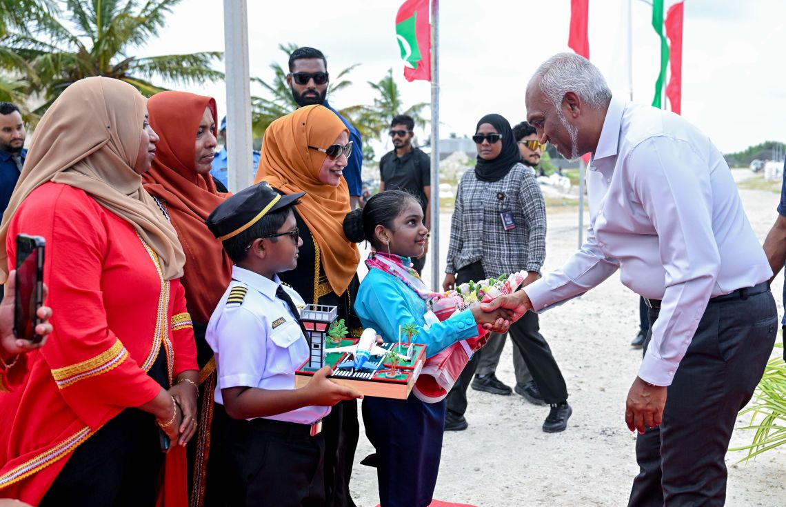ރައީސް މިލަންދޫ އަށް ވަޑައިގަތުމުން އެމަނިކުފާނަށް މަރުހަބާ ދެންނެވުމަށް ކެބިންކްރޫ އެއްގެ ޔުނިފޯމް އަޅައިގެން ހުރި އަންހެން ކުއްޖެއްގެ އިތުރުން ޕައިލްޓް ޔުނިފޯމެއް އަޅައިގެން ހުރި ފިރިހެން ކުއްޖެއް. - ފޮޓޯ: ރައީސް އޮފީސް